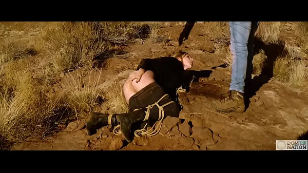 Big-ass blonde gets her asshole whipped, then gets rough anal sex in dirt and piss -- a real BDSM session outdoors in the Western USA with Rebel Rhyder